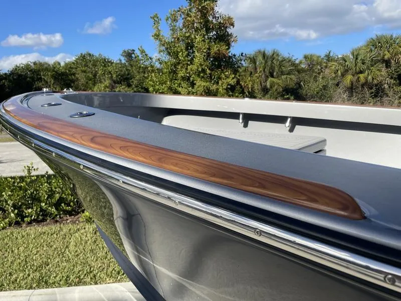 Slide: The Image of The image shows the bow of a 2020 Stuart 27 CC boat with wood trim. - 50