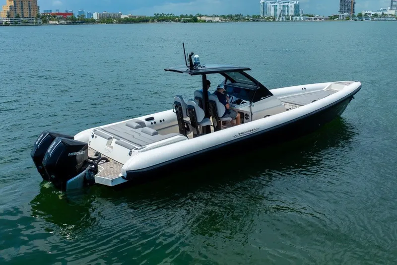 Slide: The Image of 2021 Technohull 38 Grand Sport boat on calm water, featuring dual Mercury engines. - 10