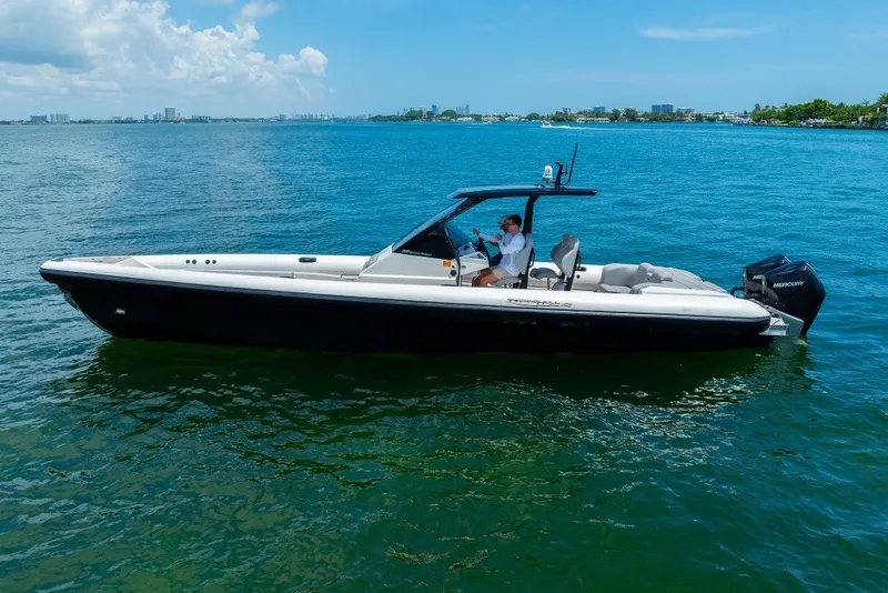 Slide: The Image of 2021 Technohull 38 Grand Sport boat cruising on clear blue water. - 13