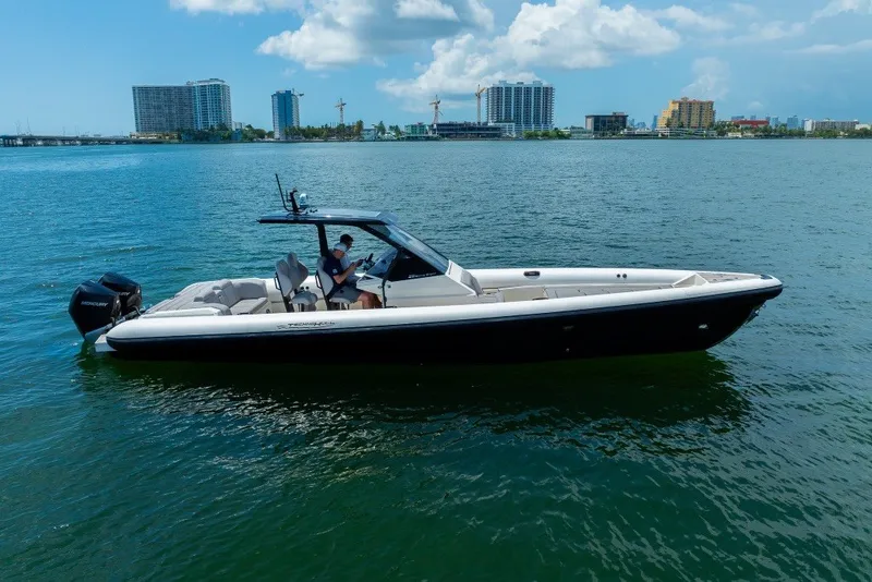 Slide: The Image of 2021 Technohull 38 Grand Sport boat on calm water with city skyline background. - 9