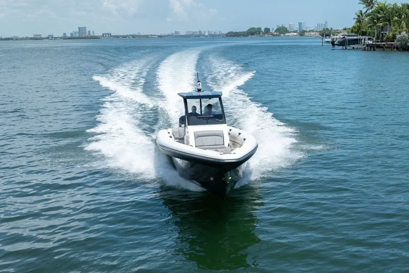 Slide: The Image of 2021 Technohull 38 Grand Sport speeding on open water, city skyline in background. - 23