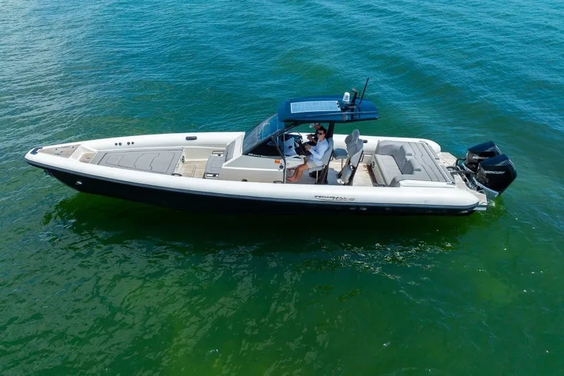 Slide: The Image of 2021 Technohull 38 Grand Sport boat cruising on clear blue water. - 4
