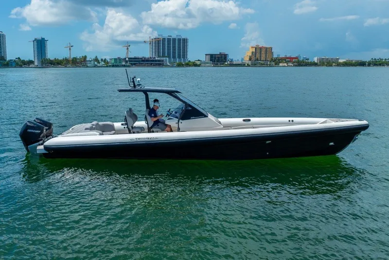 Slide: The Image of 2021 Technohull 38 Grand Sport boat on calm water with city skyline background. - 16