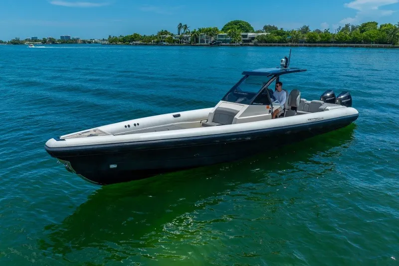 Slide: The Image of 2021 Technohull 38 Grand Sport boat cruising on clear blue water. - 14
