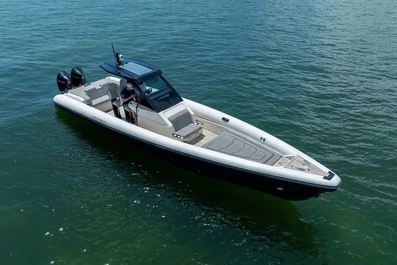 Slide: The Image of 2021 Technohull 38 Grand Sport boat on calm water, featuring sleek design and dual engines. - 7
