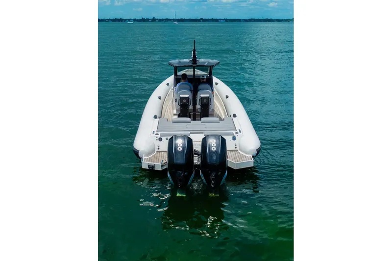 Slide: The Image of 2021 Technohull 38 Grand Sport boat on calm water, rear view with dual engines. - 11
