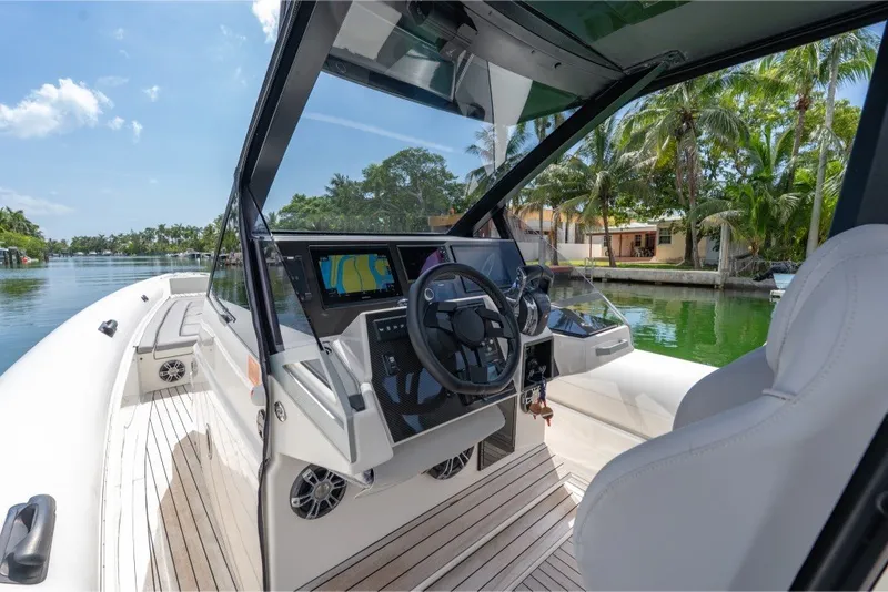 Slide: The Image of 2021 Technohull 38 Grand Sport boat interior with modern dashboard and scenic waterfront view. - 30