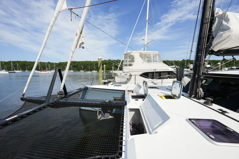 Slide: The Image of Modern Balance 482 catamaran docked at marina, surrounded by sailboats under clear blue sky. - 63