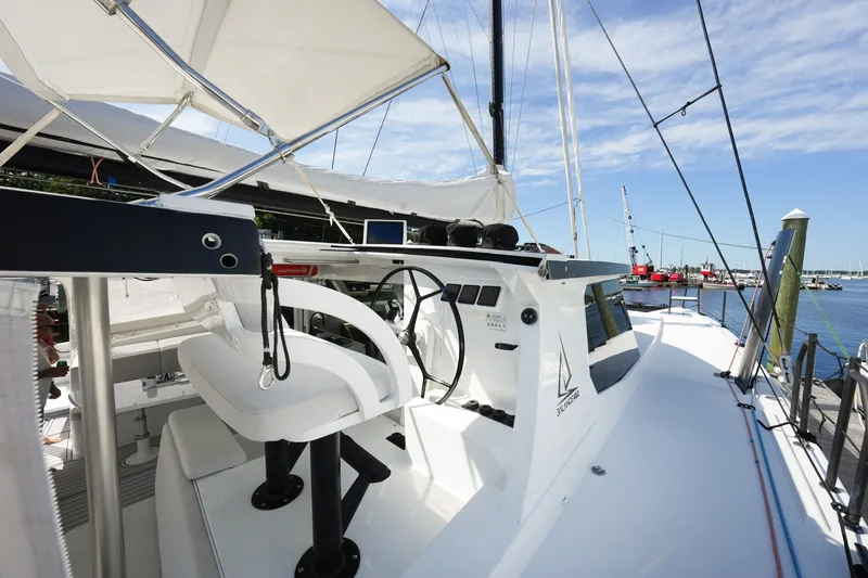 Slide: The Image of Modern Balance 482 yacht cockpit with steering wheel, docked at marina, under clear blue sky. - 18