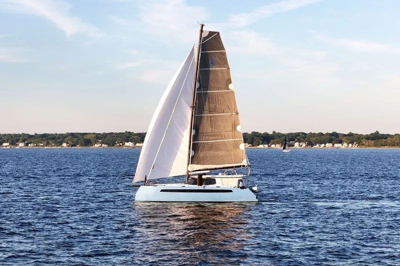 Slide: The Image of Sailing catamaran Balance 482, 2022 model, gliding on serene waters near a distant shoreline. - 6