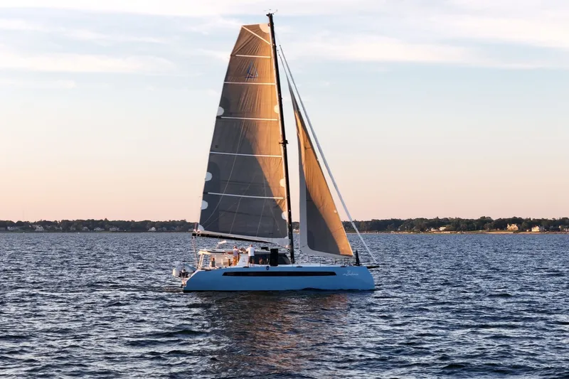Slide: The Image of Sailing catamaran Balance 482, 2022 model, gliding on serene waters at sunset. - 5