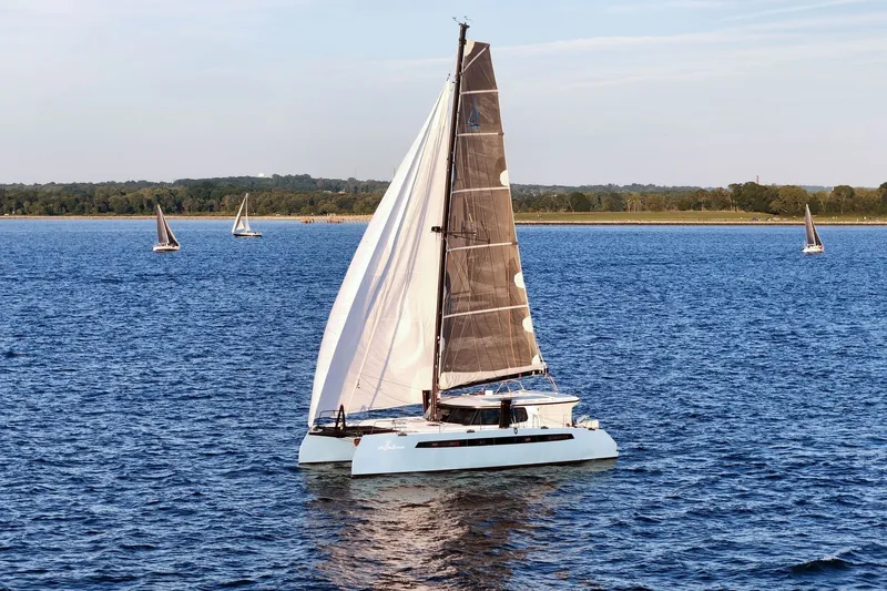 Slide: The Image of 2022 Balance 482 catamaran sailing on a serene blue sea with distant sailboats. - 80