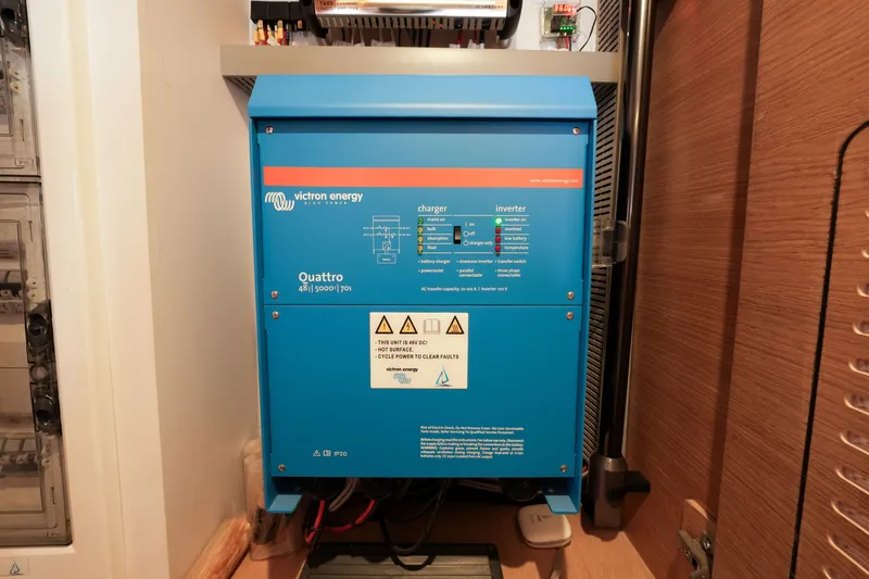 Slide: The Image of Blue Victron Energy Quattro inverter model 482, installed in a utility room, 2022. - 40