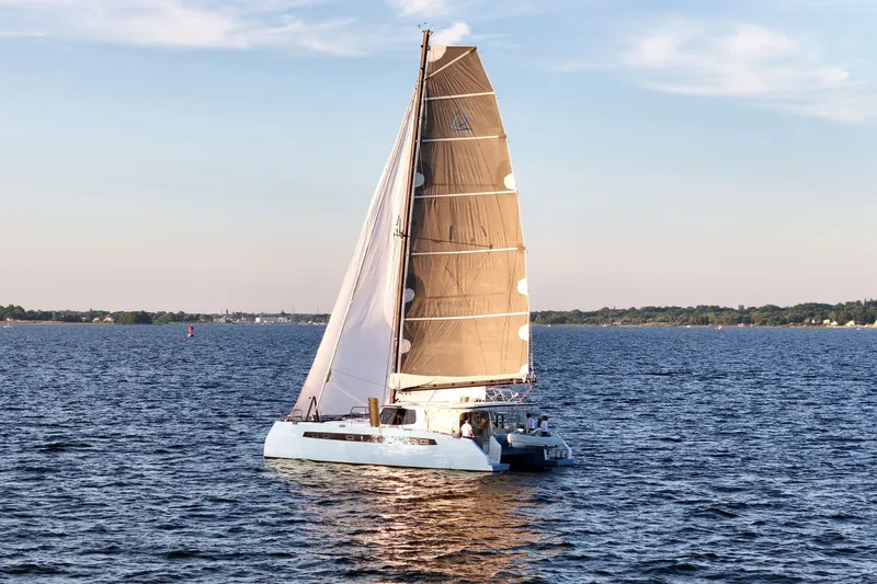 Slide: The Image of Sailing catamaran Balance 482, 2022 model, cruising on a serene lake at sunset. - 84