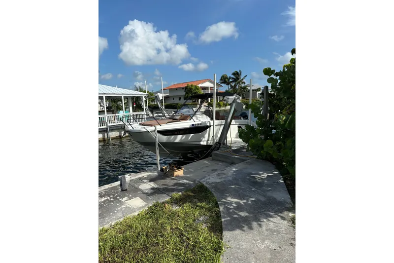 Slide: The Image of 2019 Beneteau Flyer 7.7 SPACEdeck docked by a waterfront home under a clear blue sky. - 3