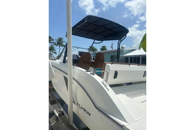 Slide: The Image of 2019 Beneteau Flyer 7.7 SPACEdeck boat with canopy, docked under sunny skies. - 2