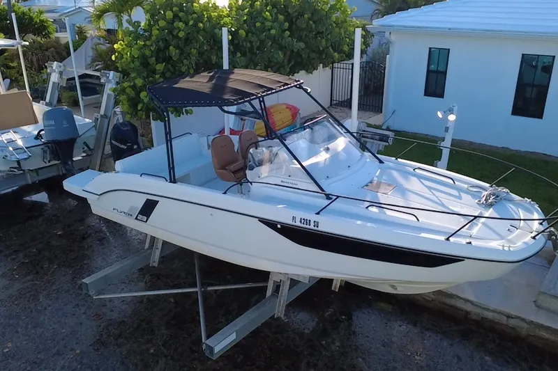 Slide: The Image of 2019 Beneteau Flyer 7.7 SPACEdeck boat on lift, docked near a house. - 0