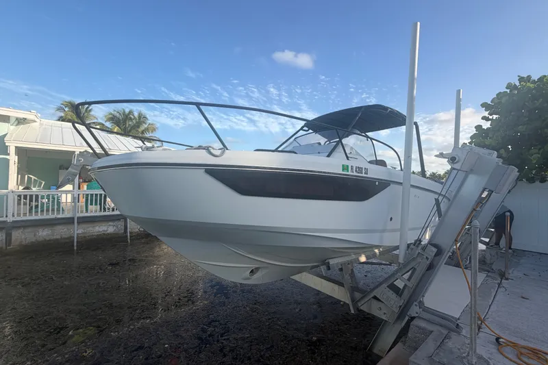 Slide: The Image of 2019 Beneteau Flyer 7.7 SPACEdeck boat on lift, sunny day, coastal background. - 7