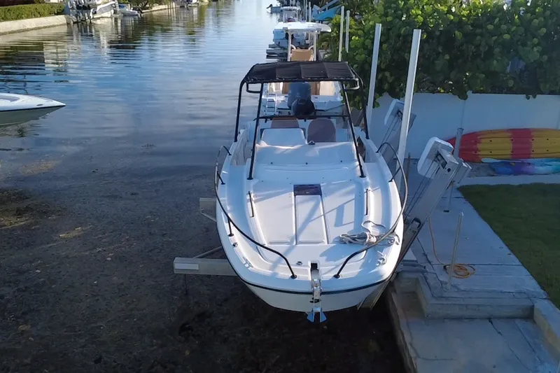 Slide: The Image of 2019 Beneteau Flyer 7.7 SPACEdeck docked in a serene canal setting. - 2