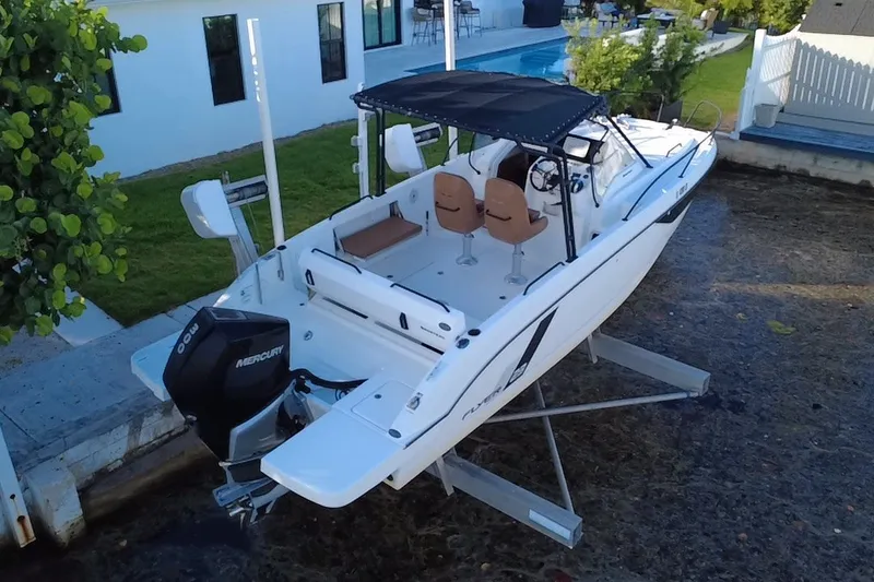 Slide: The Image of 2019 Beneteau Flyer 7.7 SPACEdeck boat with Mercury engine, docked near a poolside. - 1