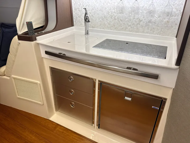 Slide: The Image of The galley of the 2020 Grady-White Canyon 456 features stainless steel appliances and a sleek countertop. - 45