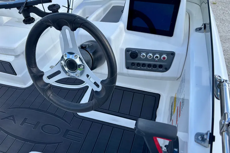Slide: The Image of 2024 Tahoe T16 boat dashboard with steering wheel, control panel, and touchscreen display. - 8