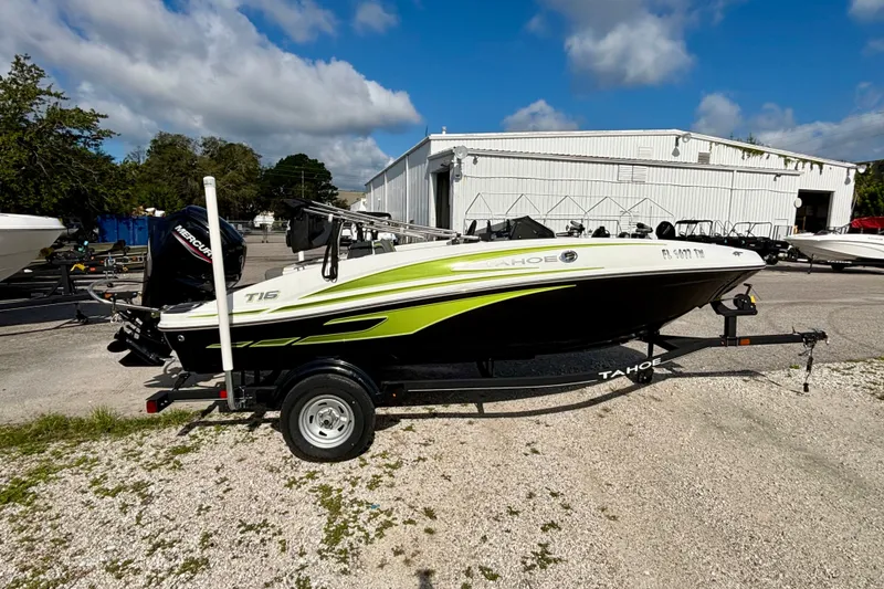 Slide: The Image of 2024 Tahoe T16 boat on trailer, parked outdoors under a clear blue sky. - 3