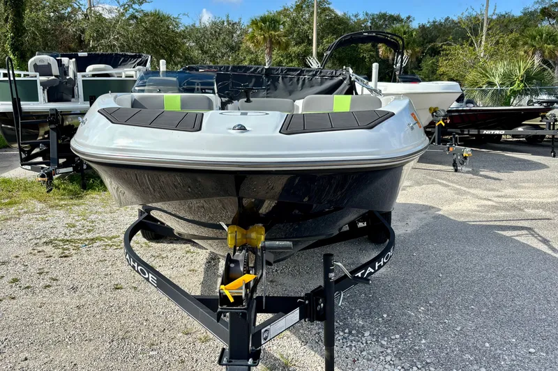 Slide: The Image of 2024 Tahoe T16 boat on trailer, parked outdoors, showcasing sleek design and modern features. - 1