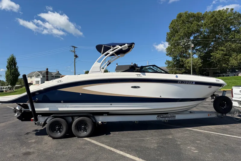 The Image of 2015 Sea Ray 270 Sundeck boat on trailer, parked outdoors under clear blue sky. - 1