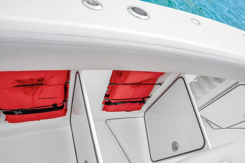 Slide: The Image of Storage compartments with red life jackets on a 2025 Solace 37CS boat. - 81