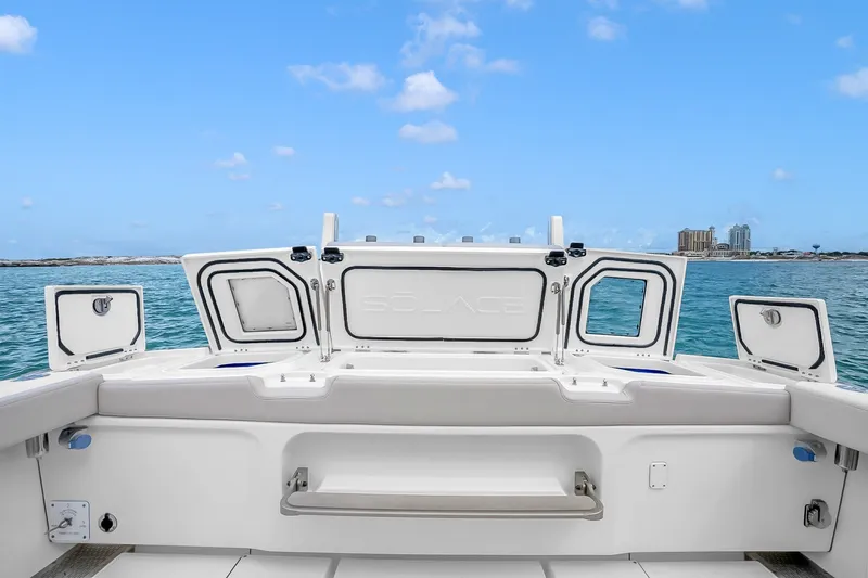 Slide: The Image of 2025 Solace 37CS boat deck with open storage compartments, ocean view, and clear blue sky. - 60