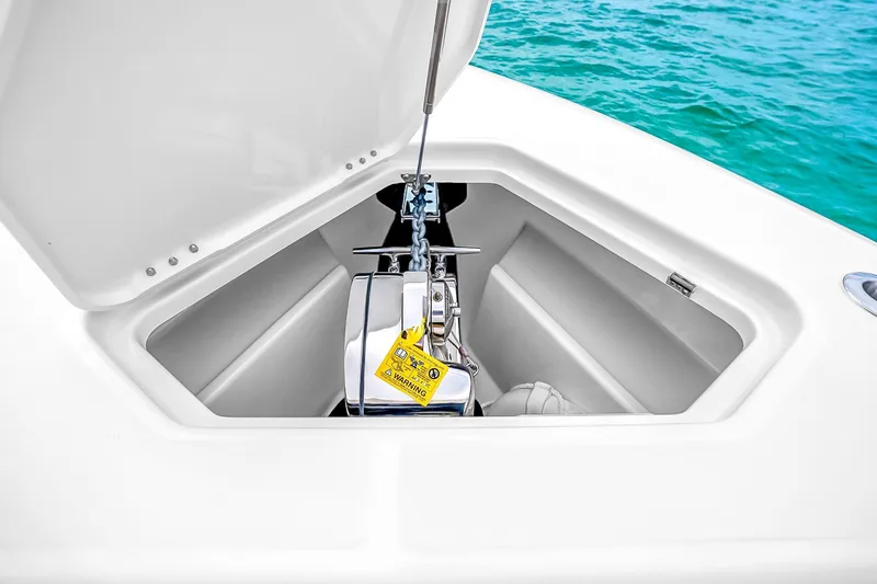 Slide: The Image of Anchor compartment of 2025 Solace 37CS boat with open hatch, near turquoise water. - 97