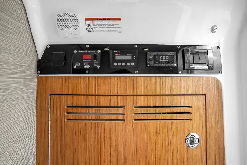 Slide: The Image of Control panel of 2025 Solace 37CS boat with wooden cabinet and electronic displays. - 37