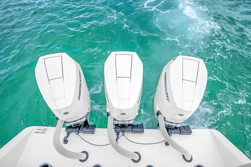 Slide: The Image of Triple Mercury outboard engines on a 2025 Solace 37CS boat in turquoise waters. - 70