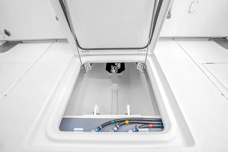 Slide: The Image of Open hatch of 2025 Solace 37CS boat showing storage compartment and hoses. - 57