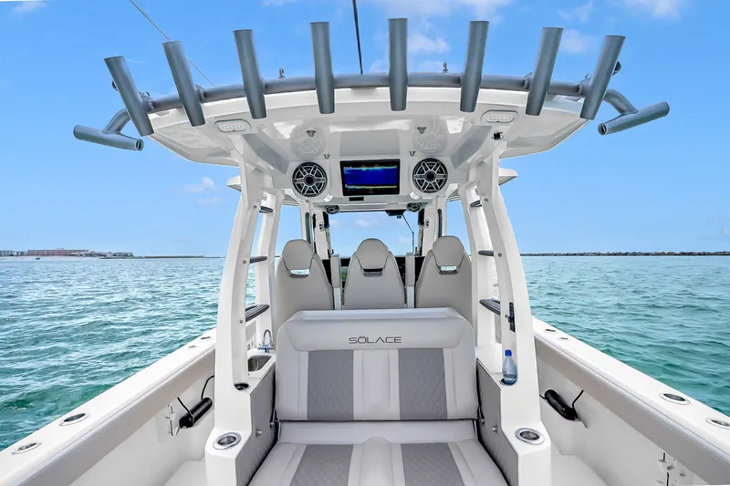Slide: The Image of 2025 Solace 37CS boat interior with seating, rod holders, and ocean view. - 45