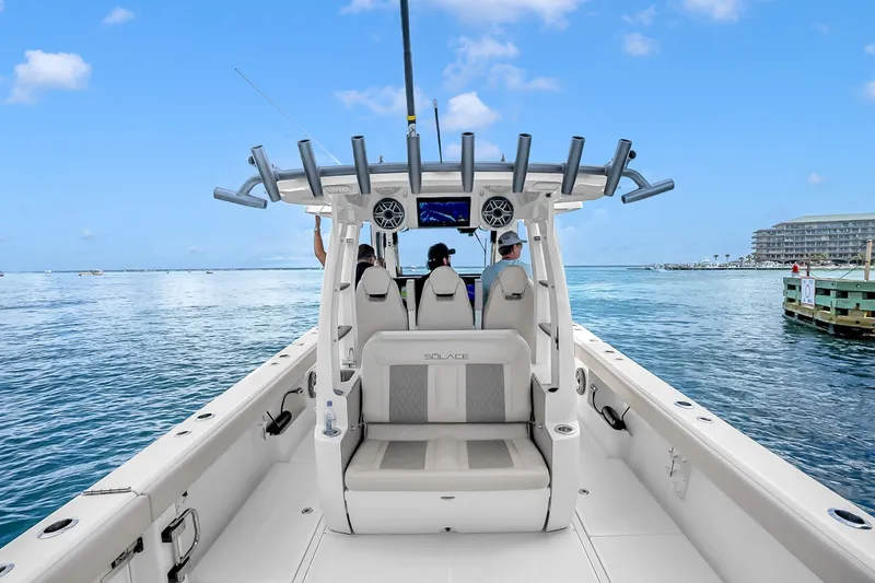 Slide: The Image of 2025 Solace 37CS boat on calm water, featuring modern seating and fishing rod holders. - 43