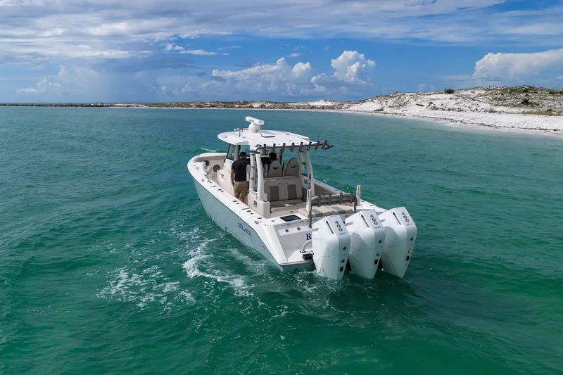 Slide: The Image of 2025 Solace 37CS boat cruising in turquoise waters near a sandy shoreline. - 19