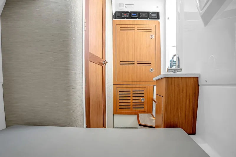 Slide: The Image of 2025 Solace 37CS cabin interior with wooden cabinetry and modern fixtures. - 36