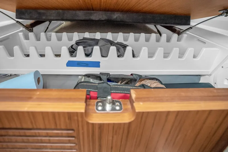 Slide: The Image of Storage compartment in 2025 Solace 37CS boat, featuring organized shelves and gear. - 39