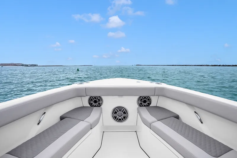 Slide: The Image of 2025 Solace 37CS boat interior with ocean view, featuring cushioned seating and speakers. - 102