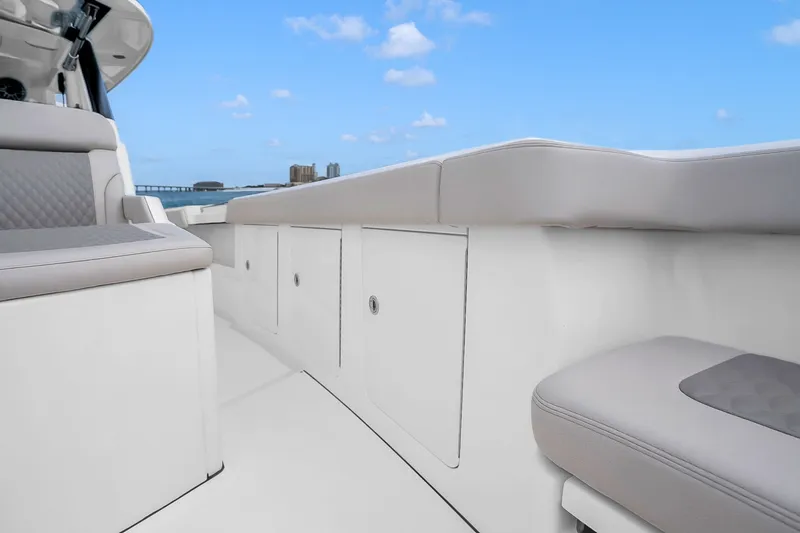 Slide: The Image of 2025 Solace 37CS boat interior with sleek seating and storage, under a clear blue sky. - 86