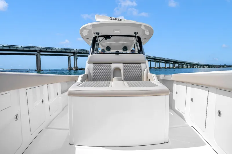 Slide: The Image of 2025 Solace 37CS boat interior with luxurious seating, under a clear blue sky near a bridge. - 101
