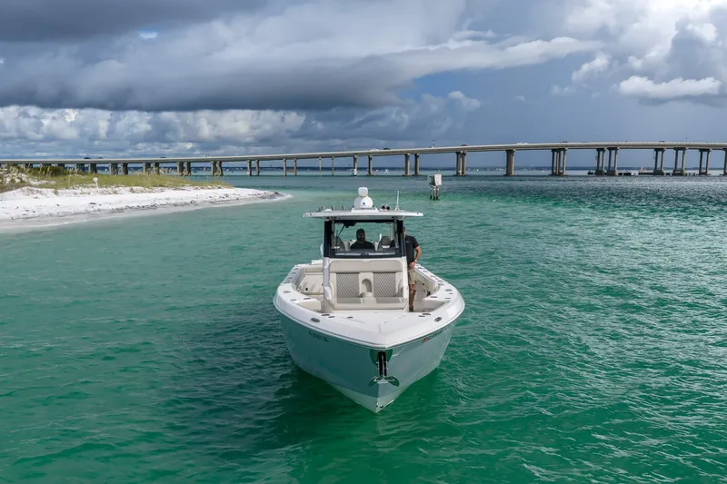 Slide: The Image of 2025 Solace 37CS boat cruising in turquoise waters near a bridge under cloudy skies. - 29