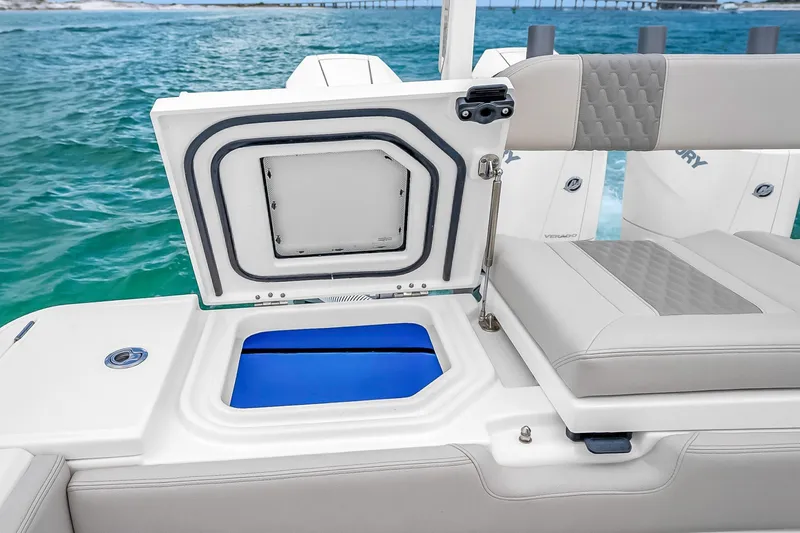Slide: The Image of 2025 Solace 37CS boat with open storage compartment, featuring luxurious seating and ocean backdrop. - 61