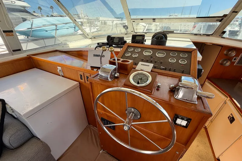 Slide: The Image of 1974 Bertram 46 Convertible yacht helm with classic wooden dashboard and steering wheel. - 19