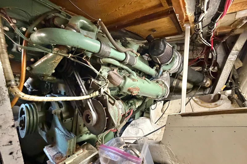 Slide: The Image of Engine room of a 1974 Bertram 46 Convertible boat, showcasing intricate machinery and wiring. - 30