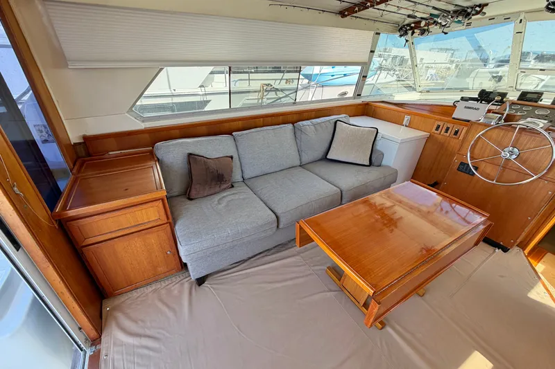 Slide: The Image of Interior of a 1974 Bertram 46 Convertible yacht with a cozy sofa and wooden table. - 16