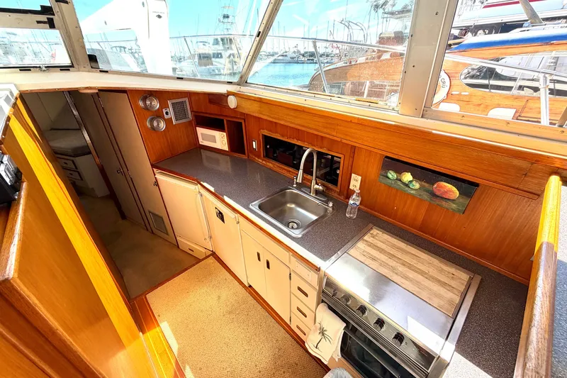Slide: The Image of 1974 Bertram 46 Convertible yacht kitchen with sink, stove, and wooden cabinetry. - 18