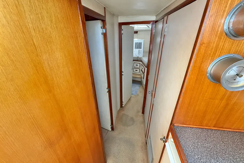 Slide: The Image of 1974 Bertram 46 Convertible yacht interior hallway with wood paneling and cabin doors. - 21